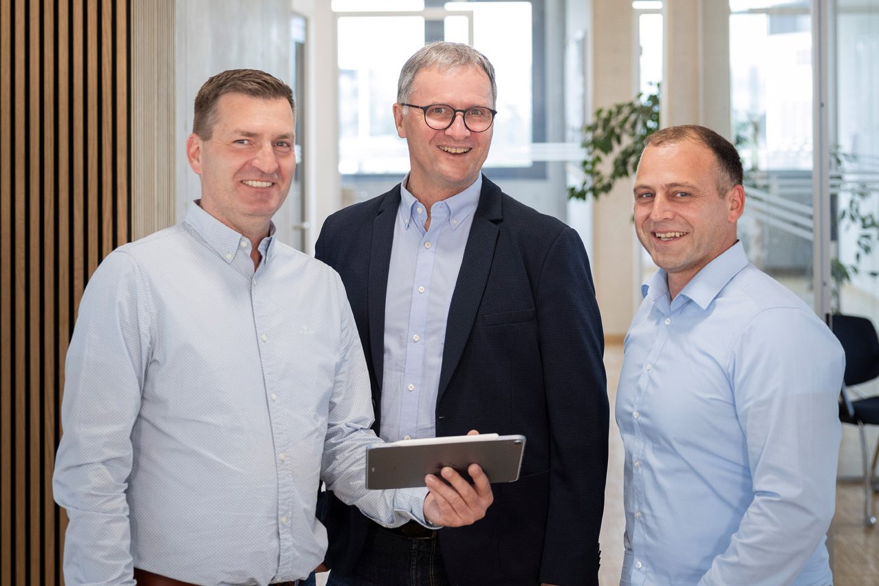 Teamfoto im Innenbereich Drei Mitarbeiter der Wucher GmbH im Büroflur – professionelles Gruppenfoto.